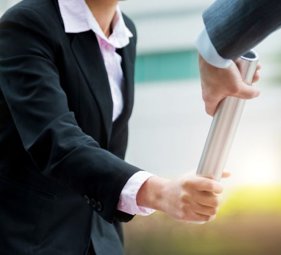Business people pass the baton outdoors.